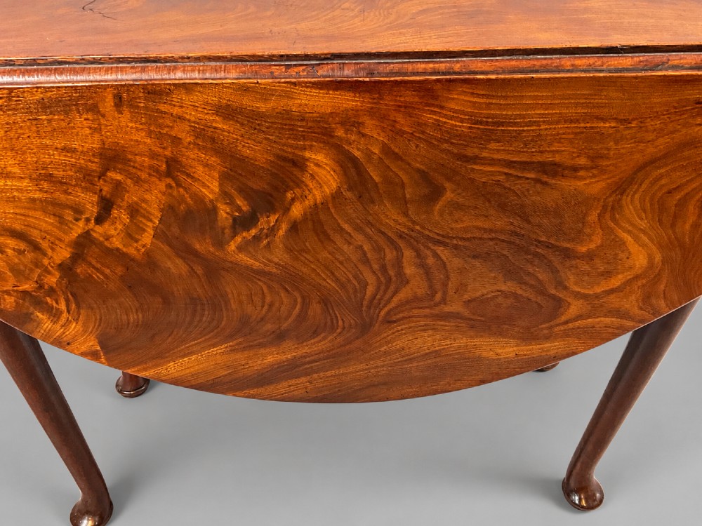 An 18th-century Georgian mahogany drop-leaf table featuring an oval top with rich grain figure and tapered legs ending in pad feet. View IV