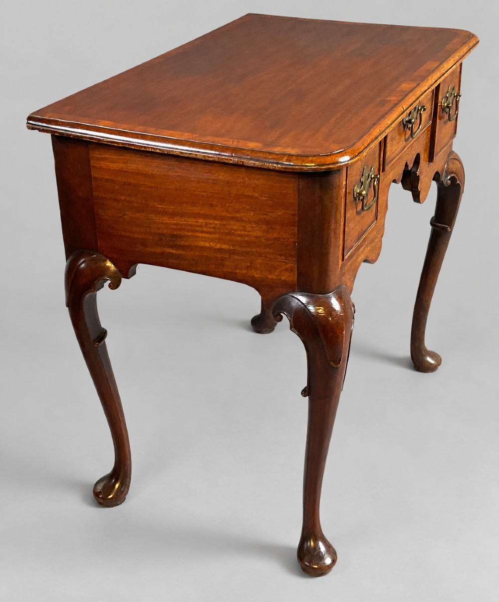 An 18th-century mahogany lowboy featuring three brass-handled drawers, a shaped apron, and four cabriole legs ending in pad feet. View II