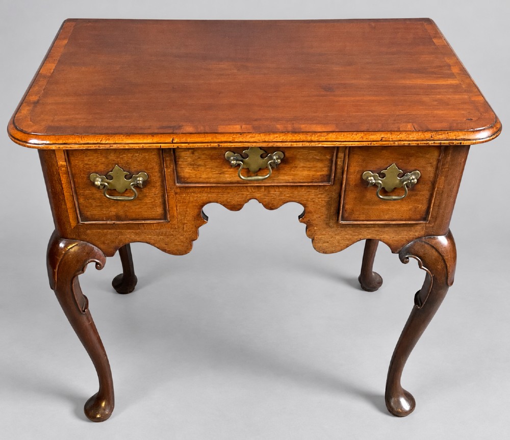 An 18th-century mahogany lowboy featuring three brass-handled drawers, a shaped apron, and four cabriole legs ending in pad feet. View IV