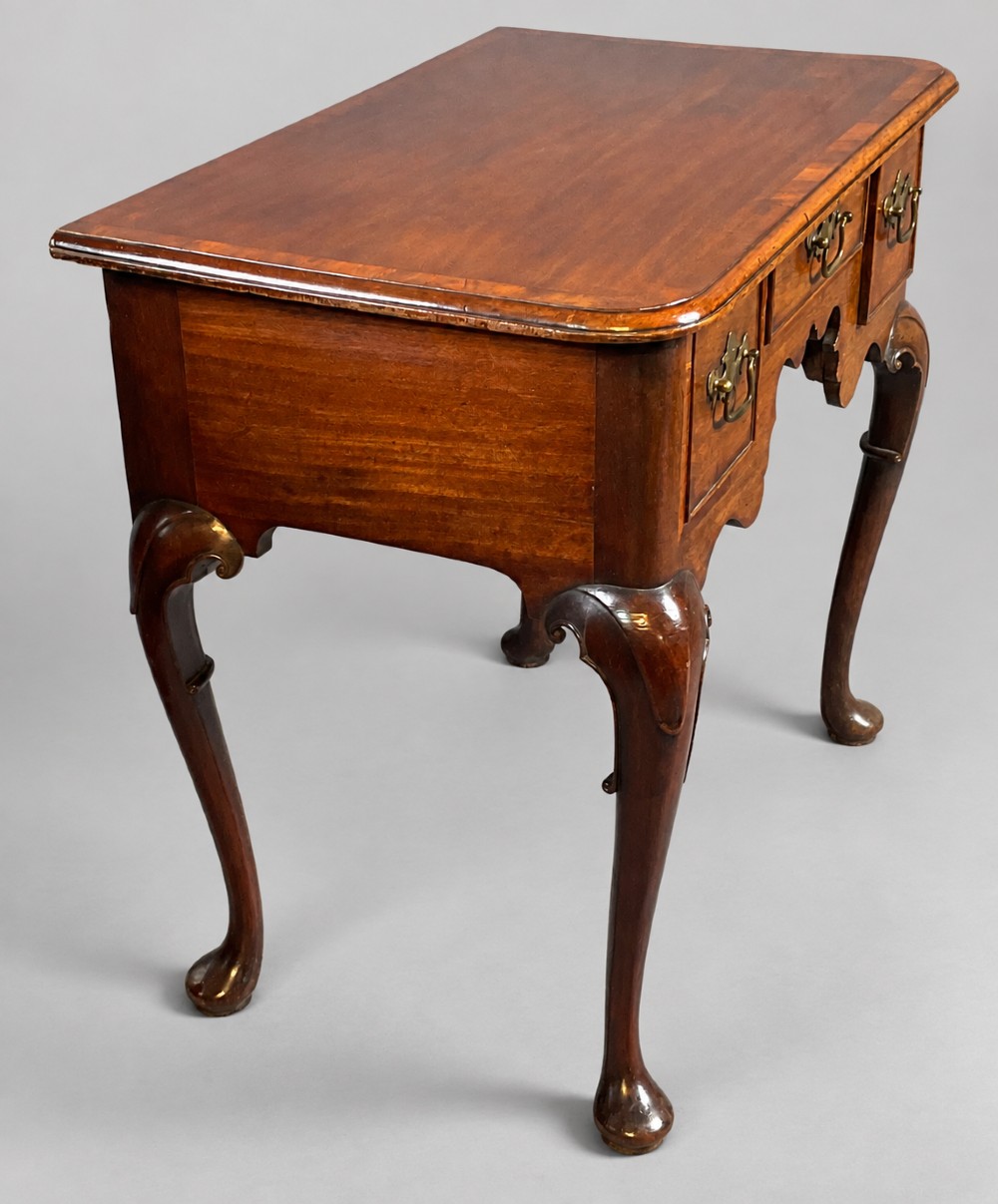 An 18th-century mahogany lowboy featuring three brass-handled drawers, a shaped apron, and four cabriole legs ending in pad feet. View VI