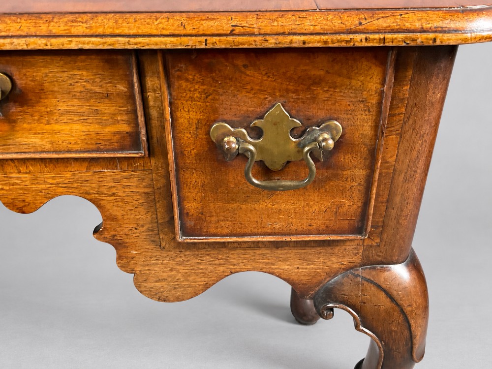 An 18th-century mahogany lowboy featuring three brass-handled drawers, a shaped apron, and four cabriole legs ending in pad feet. View VIII
