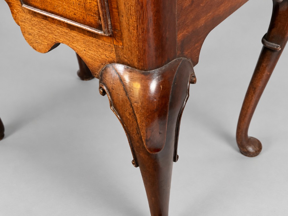 An 18th-century mahogany lowboy featuring three brass-handled drawers, a shaped apron, and four cabriole legs ending in pad feet. View X