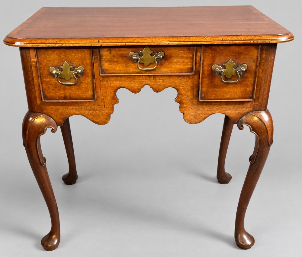 An 18th-century mahogany lowboy featuring three brass-handled drawers, a shaped apron, and four cabriole legs ending in pad feet. View XI