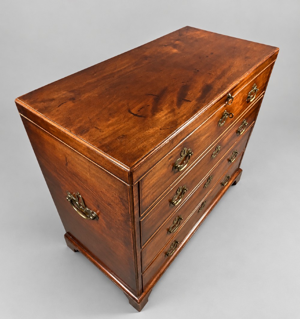An 18th-century mahogany campaign dressing chest featuring graduated drawers with brass bail handles, side carrying loops, and bracket feet.