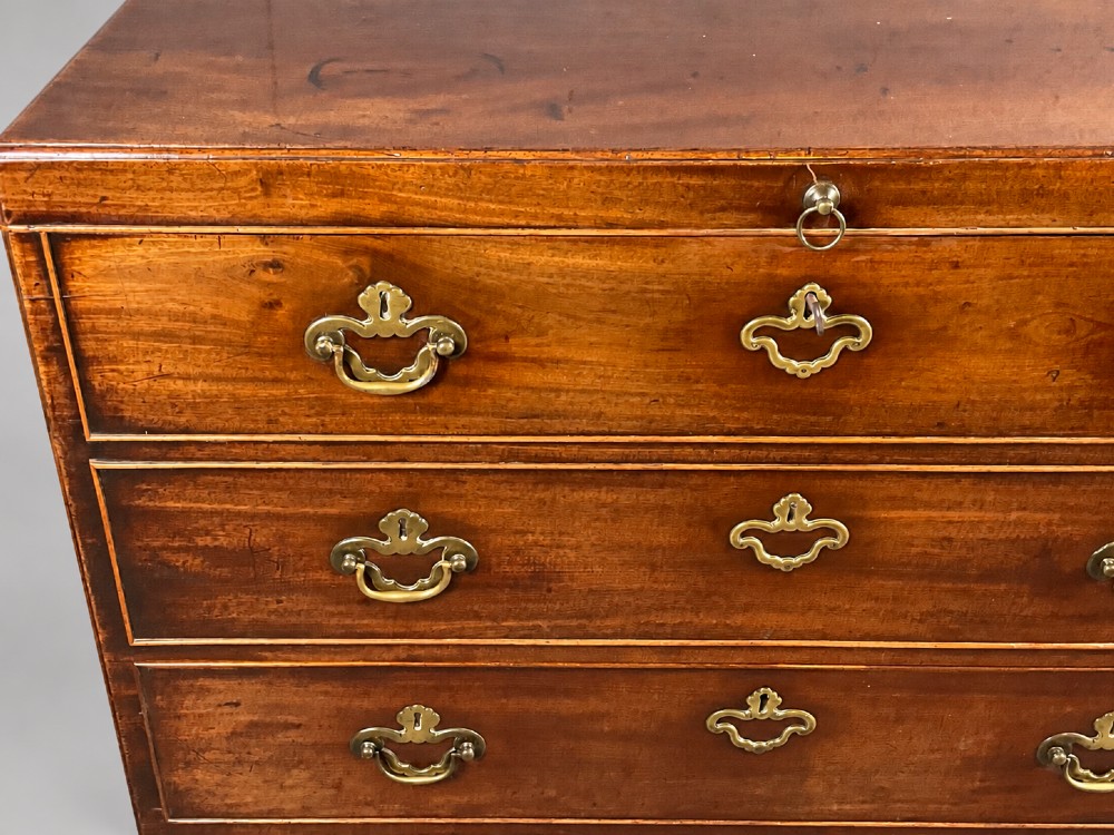 An 18th-century mahogany campaign dressing chest featuring graduated drawers with brass bail handles, side carrying loops, and bracket feet. View V