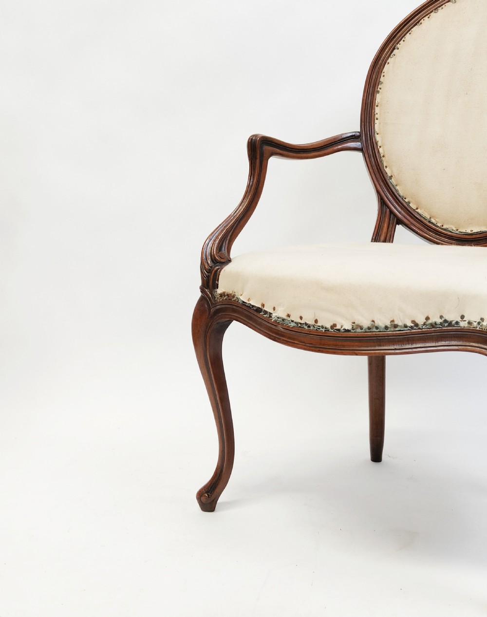 A 19th-century French open armchair featuring a carved wooden frame, medallion backrest, cabriole legs, and light cream upholstery. View III