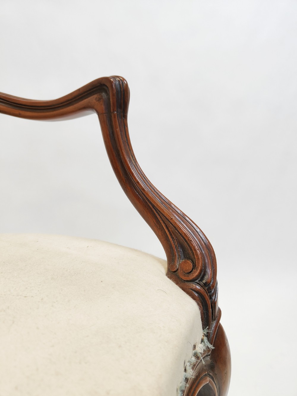 A 19th-century French open armchair featuring a carved wooden frame, medallion backrest, cabriole legs, and light cream upholstery. View VI