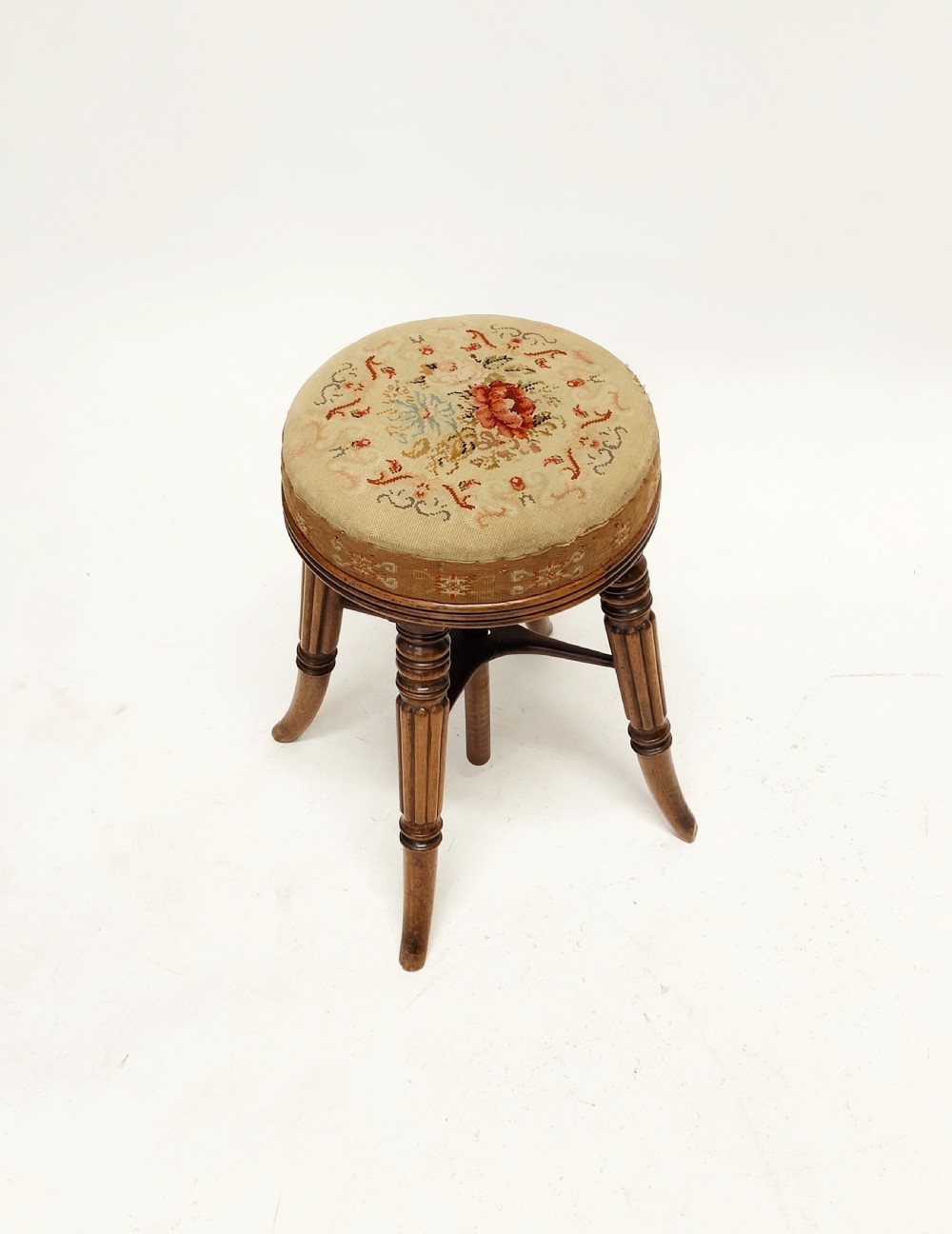 A Regency mahogany piano stool featuring a circular floral needlepoint upholstered seat, a wooden thread swivel mechanism, and four fluted legs. View III