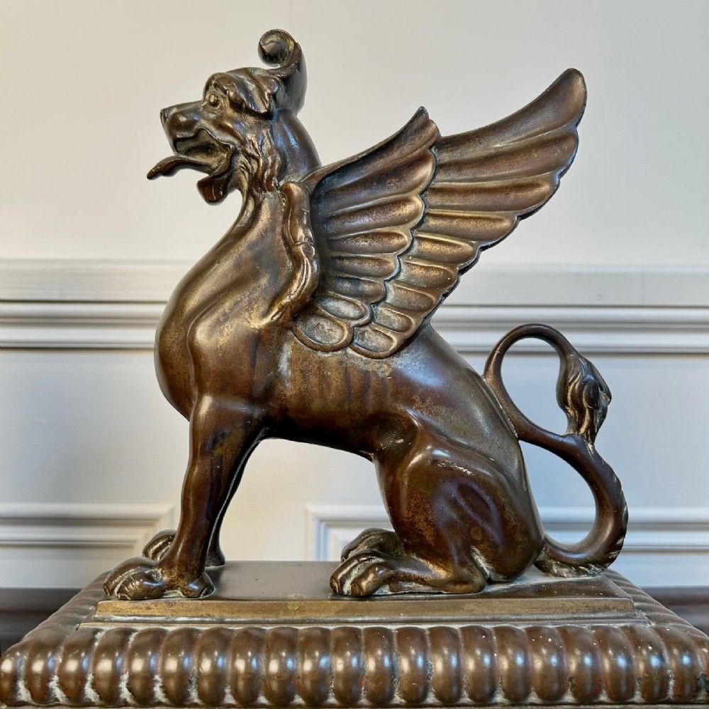 A pair of 19th-century bronzed metal griffin sculptures facing each other, mounted on stepped rectangular bases. View III