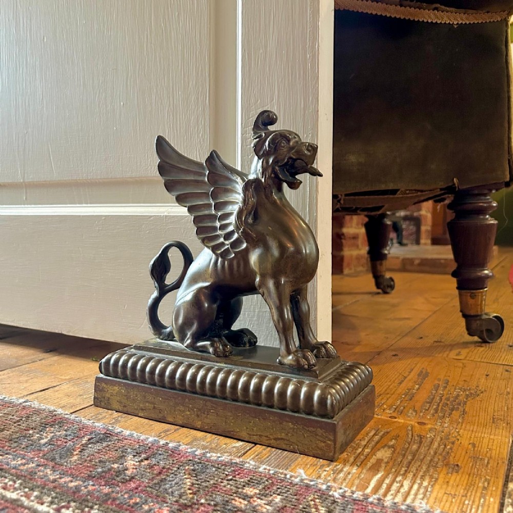 A pair of 19th-century bronzed metal griffin sculptures facing each other, mounted on stepped rectangular bases. View IV