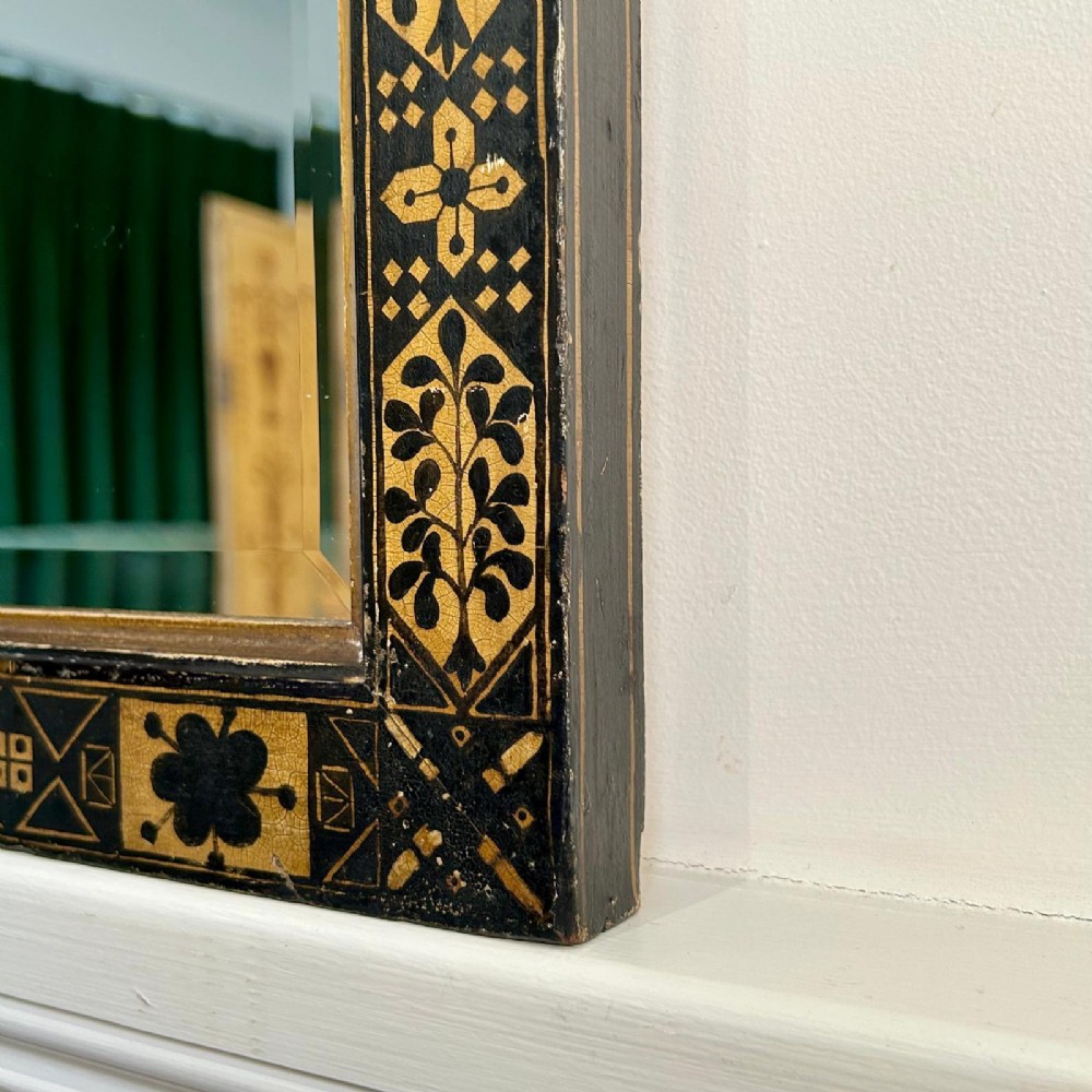 A rectangular 19th-century Italian wall mirror featuring an ebonised and gilded wooden frame decorated with geometric motifs and clover patterns. View V