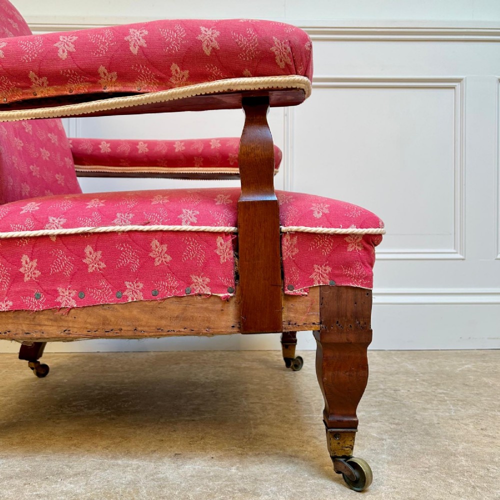 A nineteenth-century Arts and Crafts armchair featuring pink floral fabric upholstery, turned mahogany front legs, and brass castors. View VI