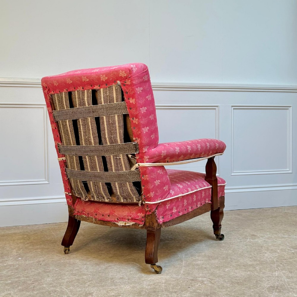 A nineteenth-century Arts and Crafts armchair featuring pink floral fabric upholstery, turned mahogany front legs, and brass castors. View VII