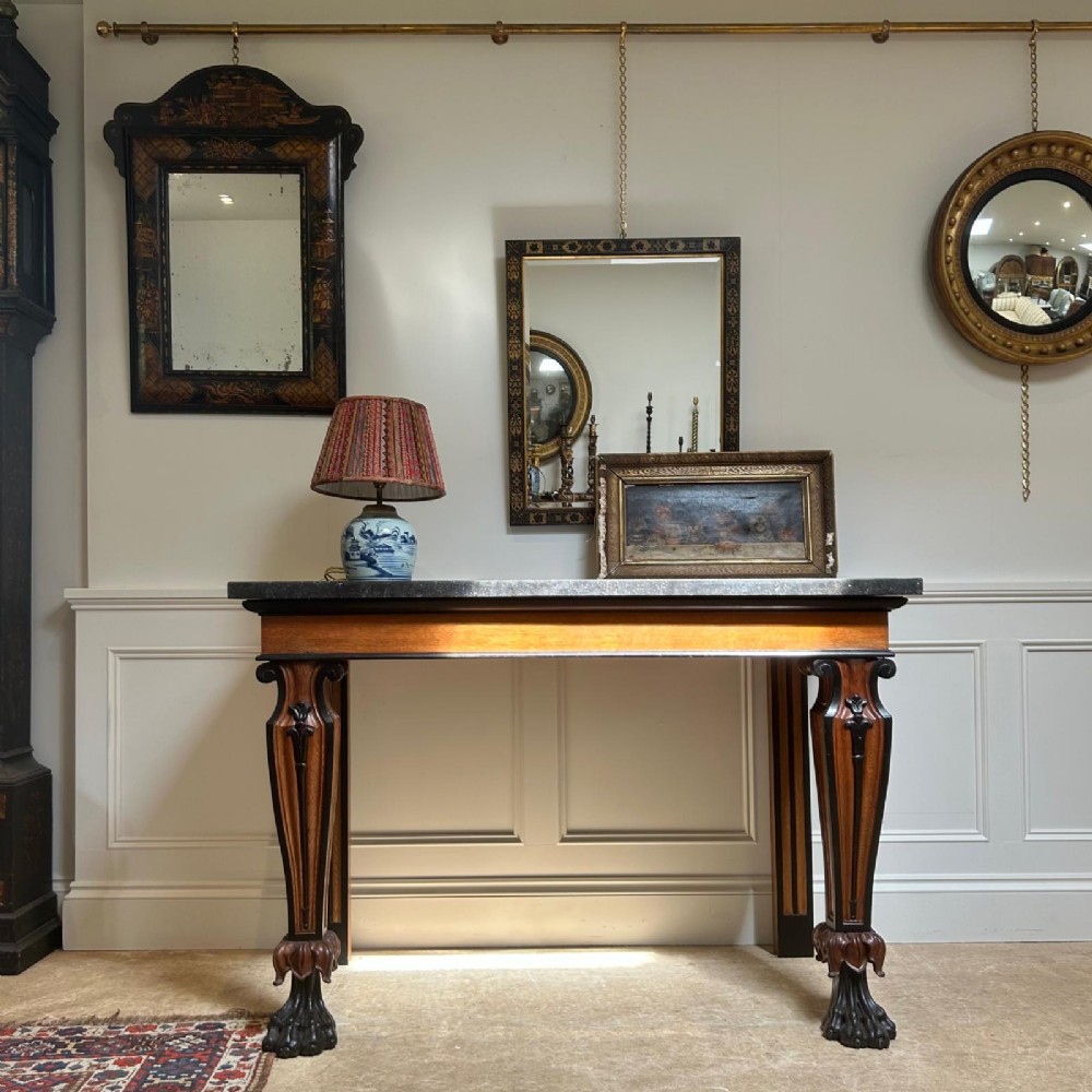 A Regency oak console table featuring a dark stone top, ebonised trim, and front legs carved with acanthus leaves and lion paw feet. View II