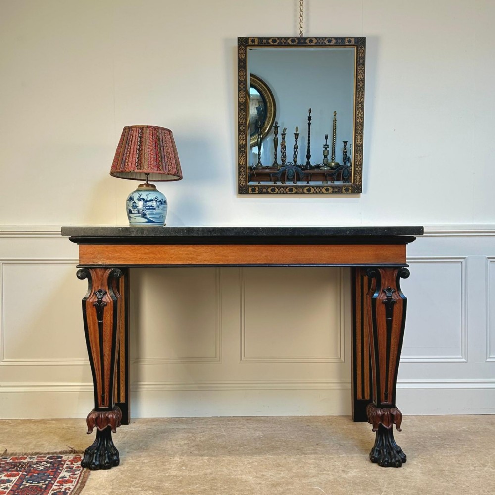 A Regency oak console table featuring a dark stone top, ebonised trim, and front legs carved with acanthus leaves and lion paw feet. View III