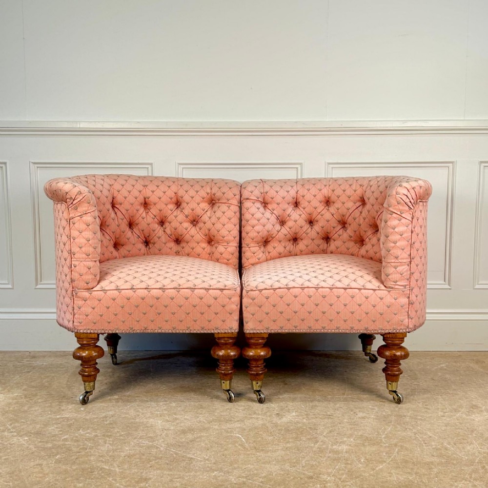 A pair of 19th-century corner armchairs upholstered in pink diamond-patterned fabric featuring button-tufted rounded backs and turned oak legs on brass castors. View IV