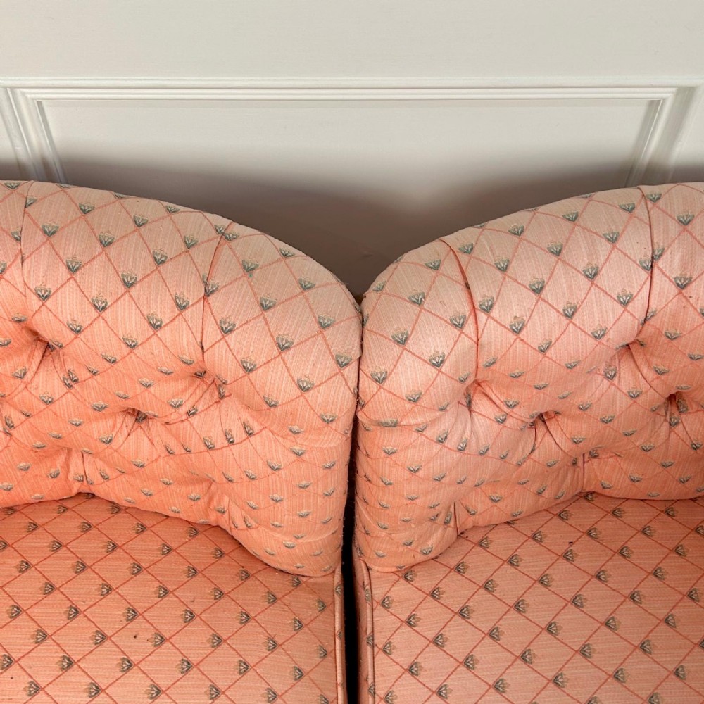 A pair of 19th-century corner armchairs upholstered in pink diamond-patterned fabric featuring button-tufted rounded backs and turned oak legs on brass castors. View VI