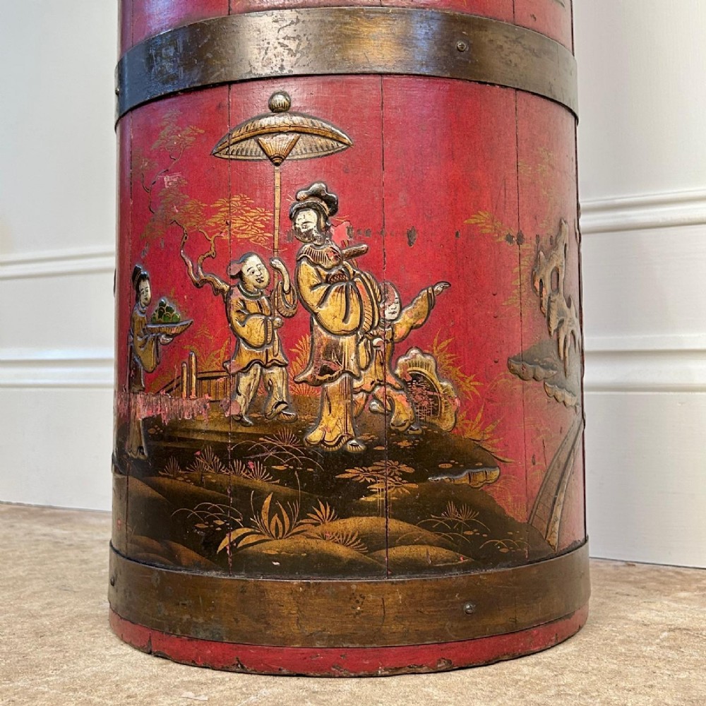 A cylindrical red Edwardian umbrella stand featuring hand-painted gold Chinoiserie scenes and bound by brass hoops. View IV