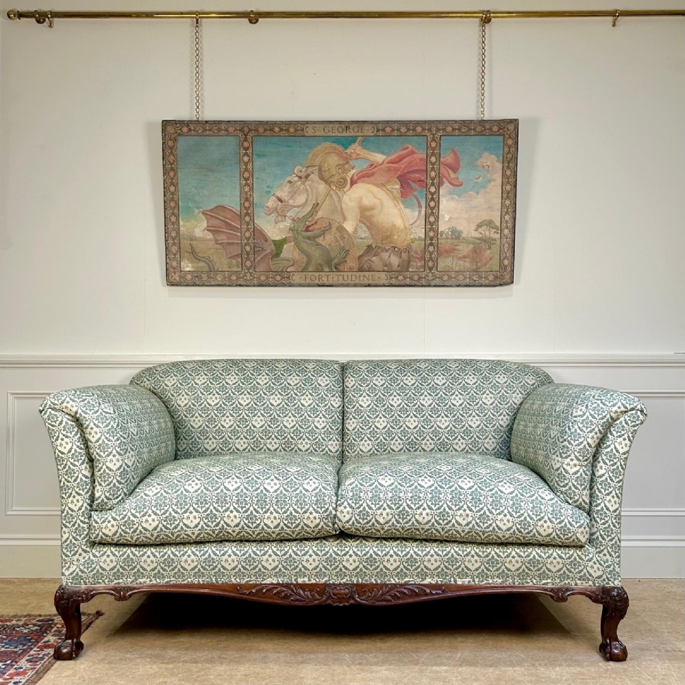 A two-seater upholstered sofa featuring sage green and cream patterned fabric with carved mahogany cabriole front legs.