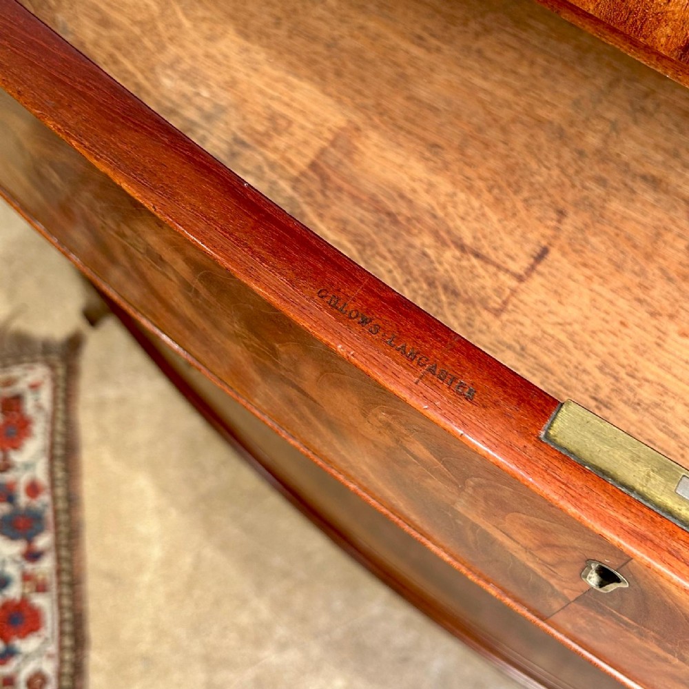 A late 18th-century Georgian flame mahogany bowfront chest of drawers featuring four graduated drawers with brass handles and splayed bracket feet. View VII