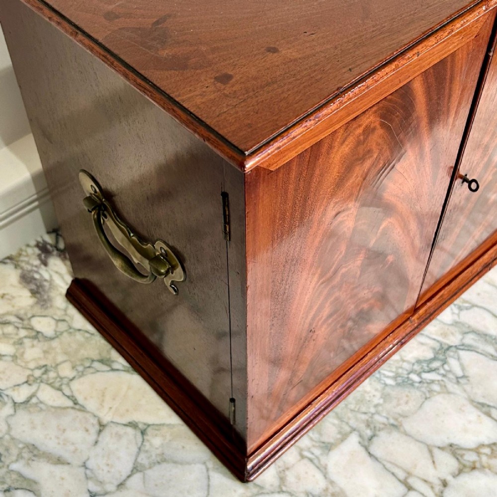 An 18th-century mahogany tabletop collectors cabinet featuring double doors that open to reveal multiple graduated internal drawers with small brass ring handles. View IV