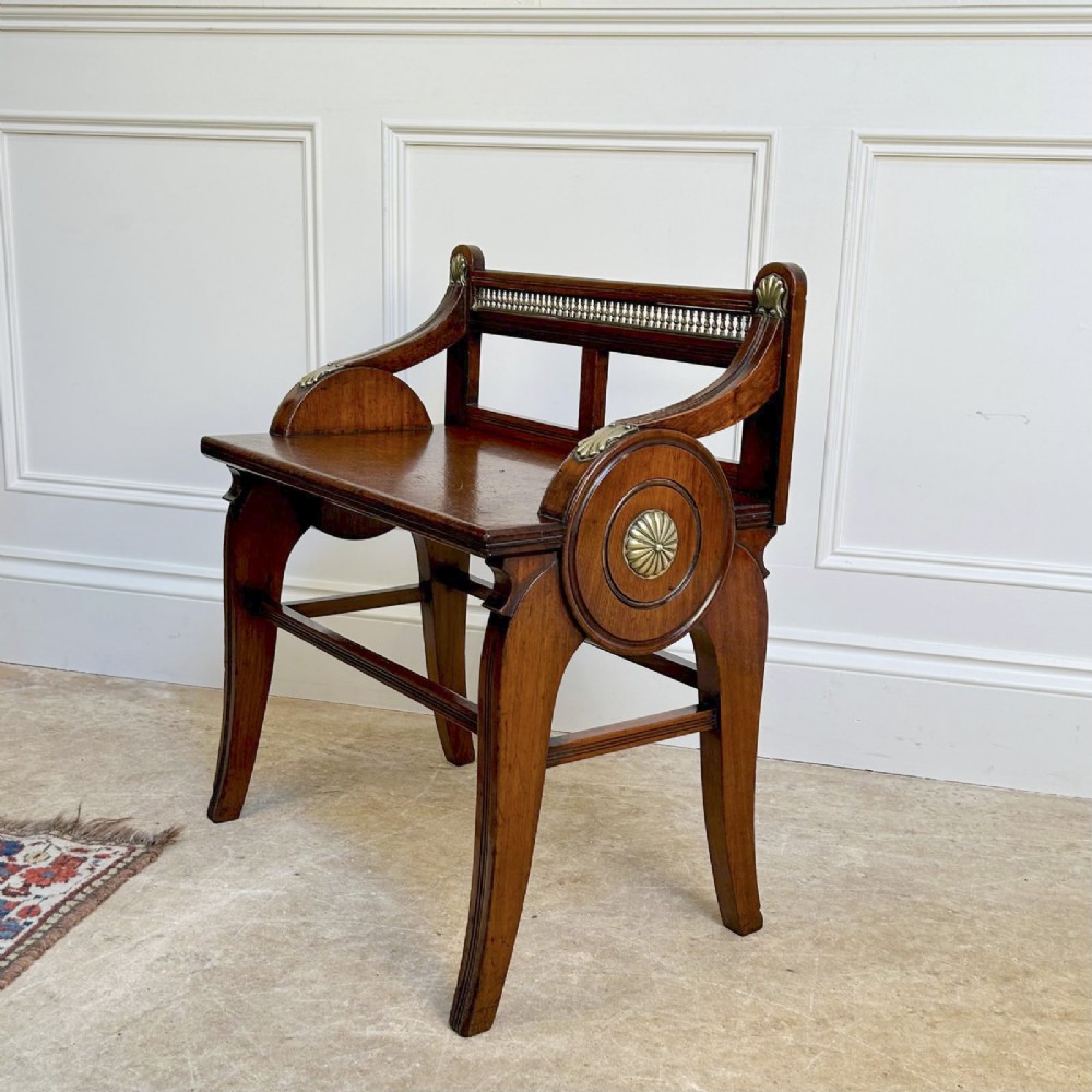 A 19th-century Victorian walnut hall bench featuring a spindle gallery back, raised arms with brass shell mounts, and reeded legs. View II