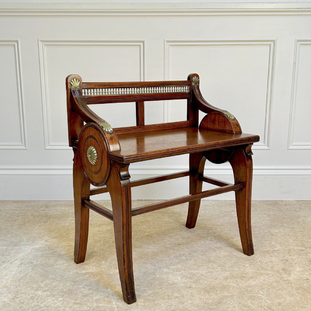 A 19th-century Victorian walnut hall bench featuring a spindle gallery back, raised arms with brass shell mounts, and reeded legs. View III