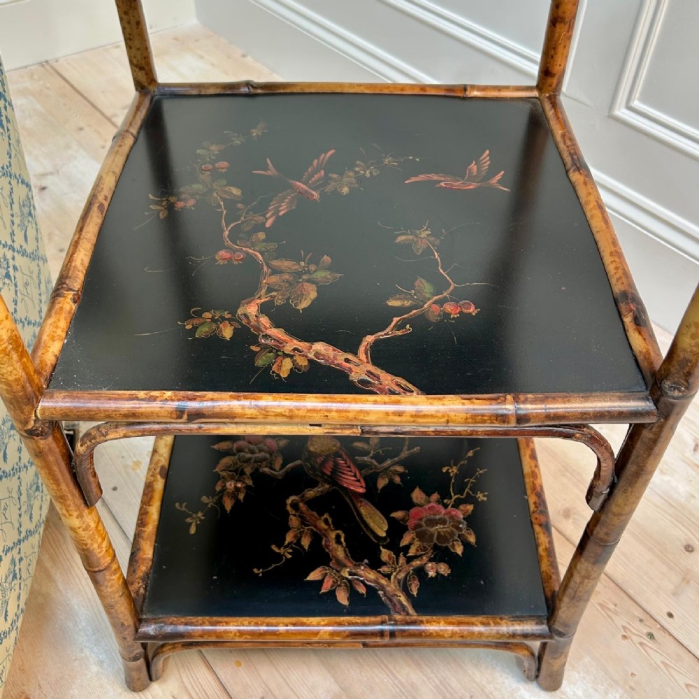 A three-tiered bamboo etagere featuring dark lacquered square shelf panels painted with bird and botanical designs. View IV