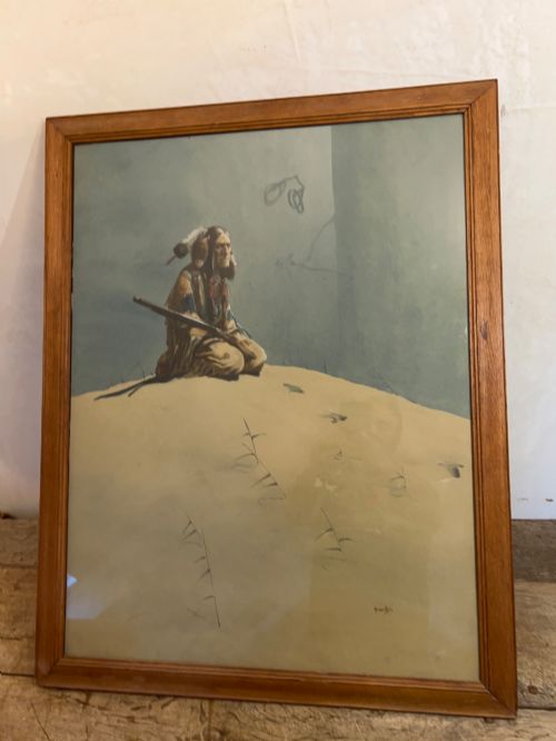 fig 1. A framed watercolour painting depicting a Native American figure seated on a grassy mound holding a rifle against a muted blue sky.