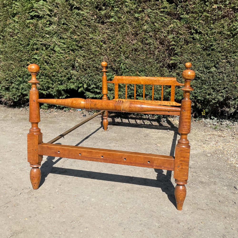 An early nineteenth-century American Federal bedstead constructed from figured tiger maple wood featuring four turned posts, cannonball finials, and a spindle headboard. View II