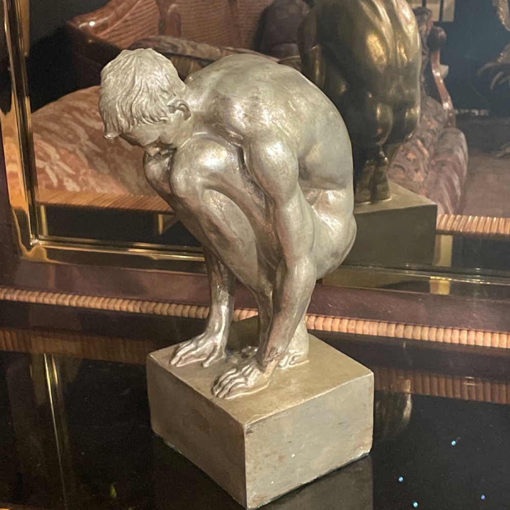 An Art Deco silvered figure of a crouching male nude