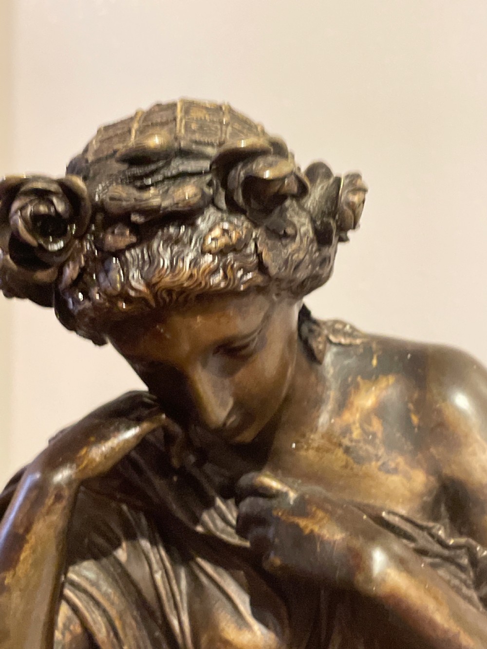 A late 19th-century French dark patinated bronze mantel clock depicting a classical draped female figure leaning upon a column containing a round dial with Roman numerals. View II