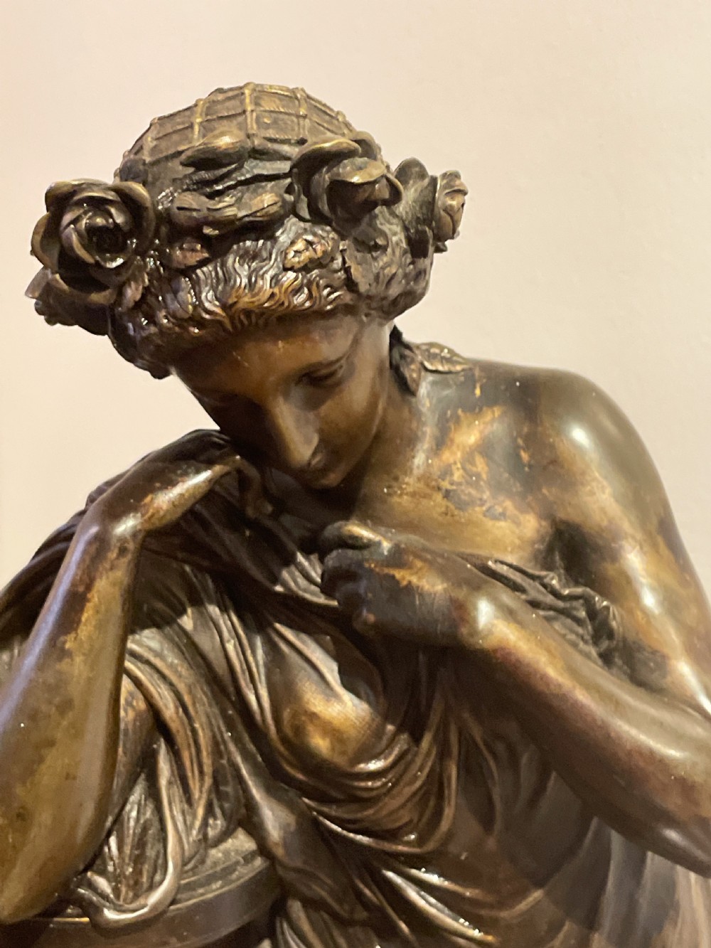A late 19th-century French dark patinated bronze mantel clock depicting a classical draped female figure leaning upon a column containing a round dial with Roman numerals. View VIII