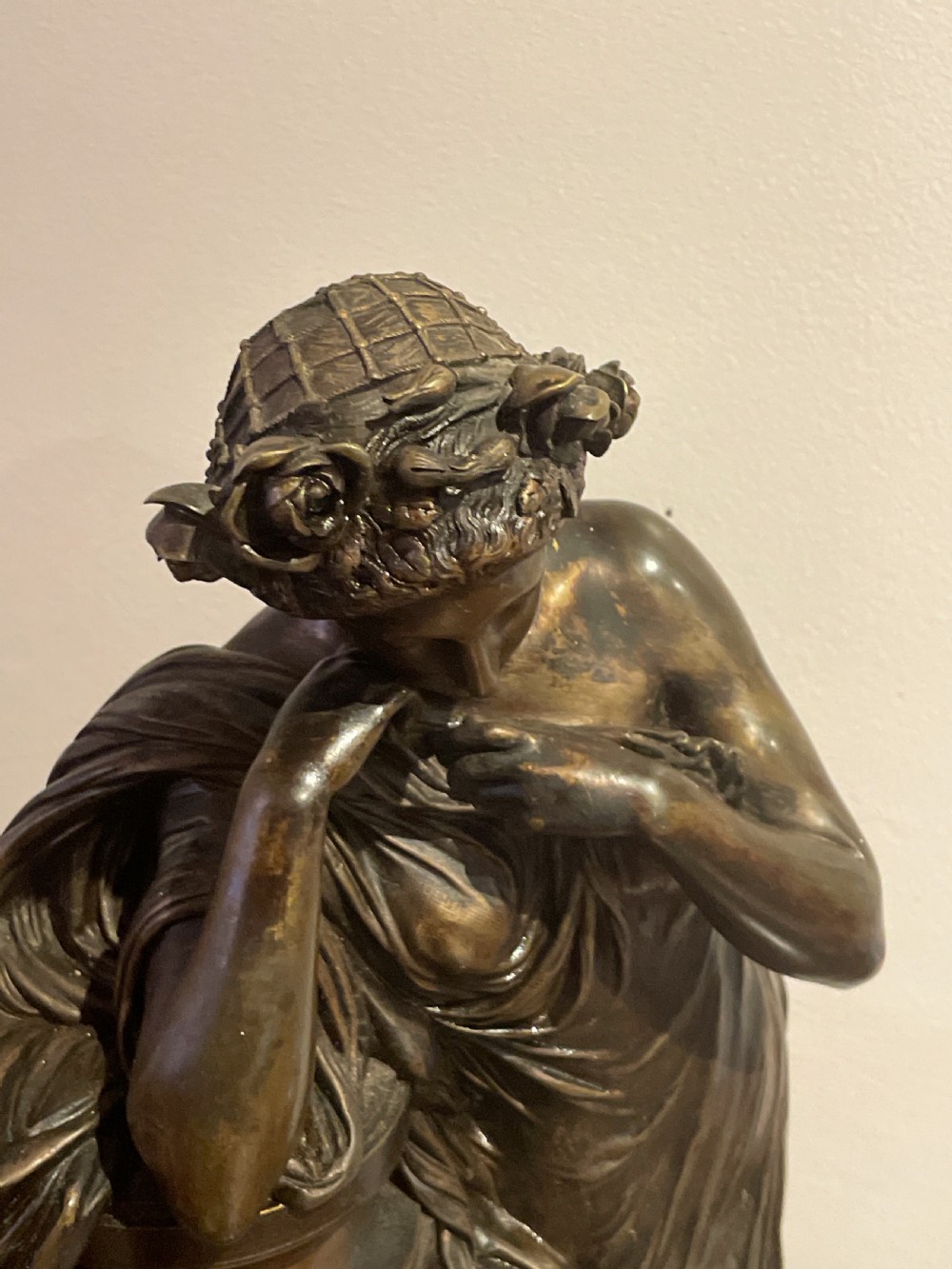 A late 19th-century French dark patinated bronze mantel clock depicting a classical draped female figure leaning upon a column containing a round dial with Roman numerals. View XI