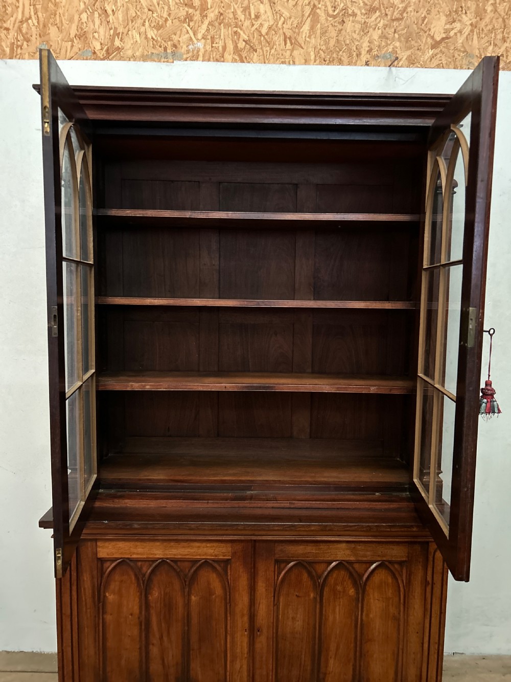 A dark George IV rosewood two-tier bookcase featuring upper glazed doors with Gothic lancet arches and lower panelled doors with tracery. View VI
