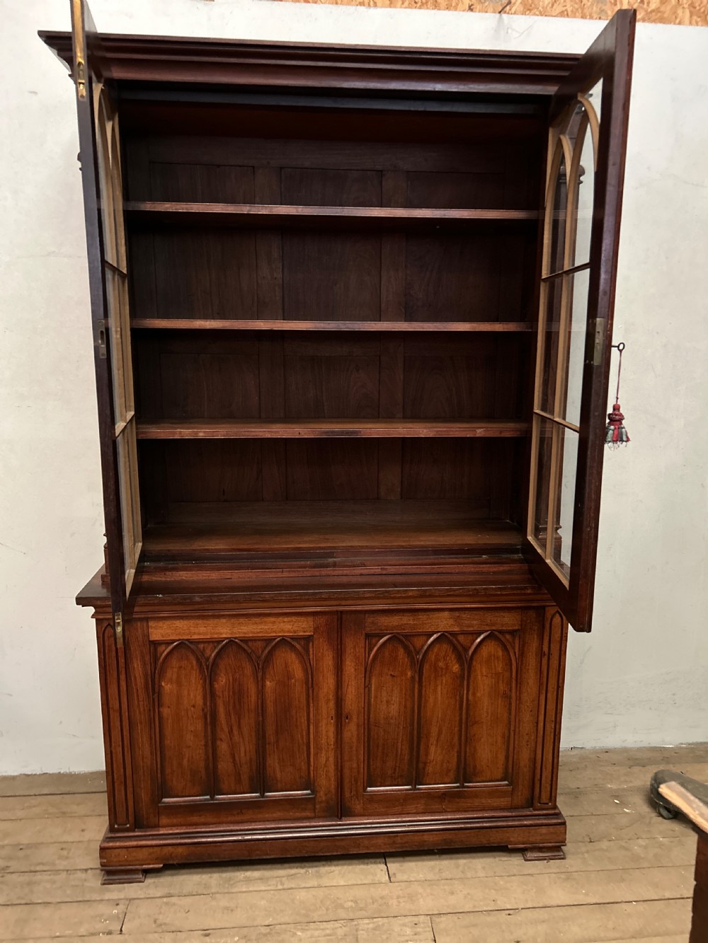 A dark George IV rosewood two-tier bookcase featuring upper glazed doors with Gothic lancet arches and lower panelled doors with tracery. View IV