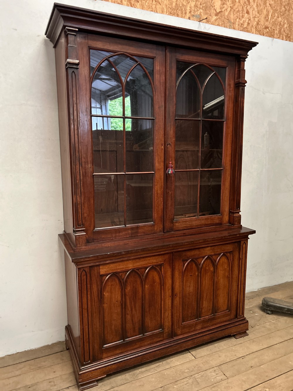 A dark George IV rosewood two-tier bookcase featuring upper glazed doors with Gothic lancet arches and lower panelled doors with tracery. View XI