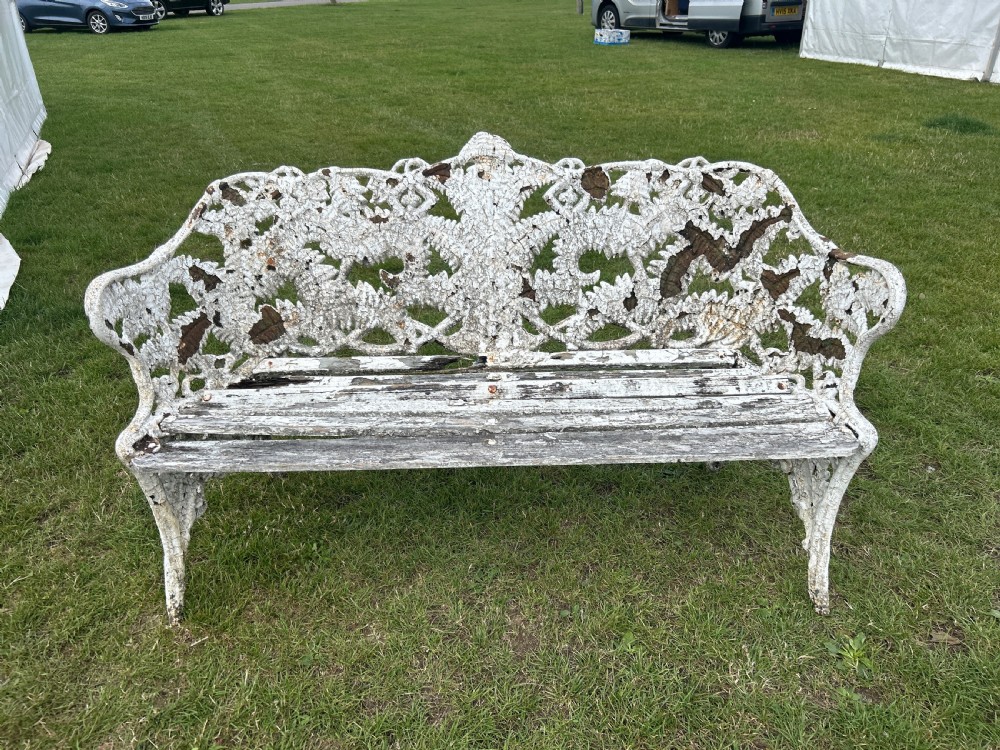 A Victorian white painted cast iron garden bench featuring detailed fern and blackberry motifs on the backrest and a wooden slatted seat. View V