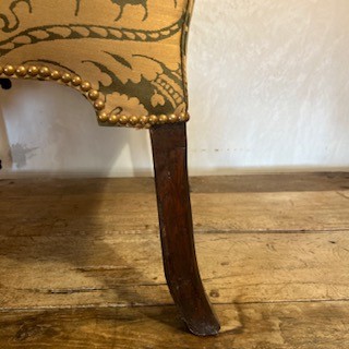 An antique George II wing armchair upholstered in patterned green damask fabric with carved walnut cabriole legs. View V