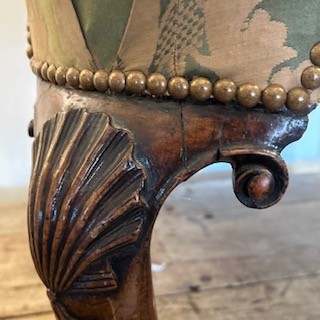 An antique George II wing armchair upholstered in patterned green damask fabric with carved walnut cabriole legs. View VII
