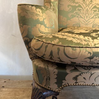 An antique George II wing armchair upholstered in patterned green damask fabric with carved walnut cabriole legs. View VIII