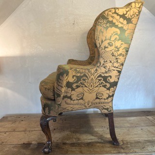 An antique George II wing armchair upholstered in patterned green damask fabric with carved walnut cabriole legs. View IX