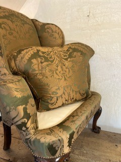 An antique George II wing armchair upholstered in patterned green damask fabric with carved walnut cabriole legs. View XI