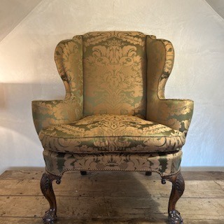 An antique George II wing armchair upholstered in patterned green damask fabric with carved walnut cabriole legs. View XII
