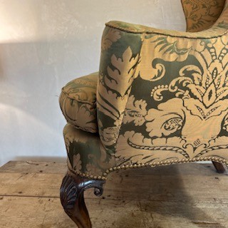An antique George II wing armchair upholstered in patterned green damask fabric with carved walnut cabriole legs. View XIV
