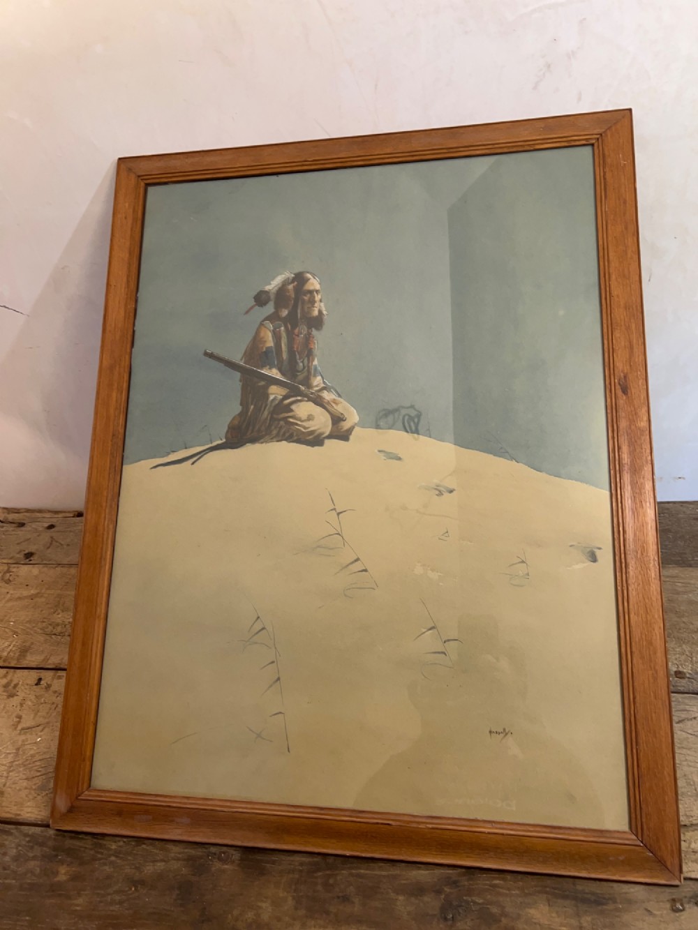 A framed watercolour painting depicting a Native American figure seated on a grassy mound holding a rifle against a muted blue sky. View III