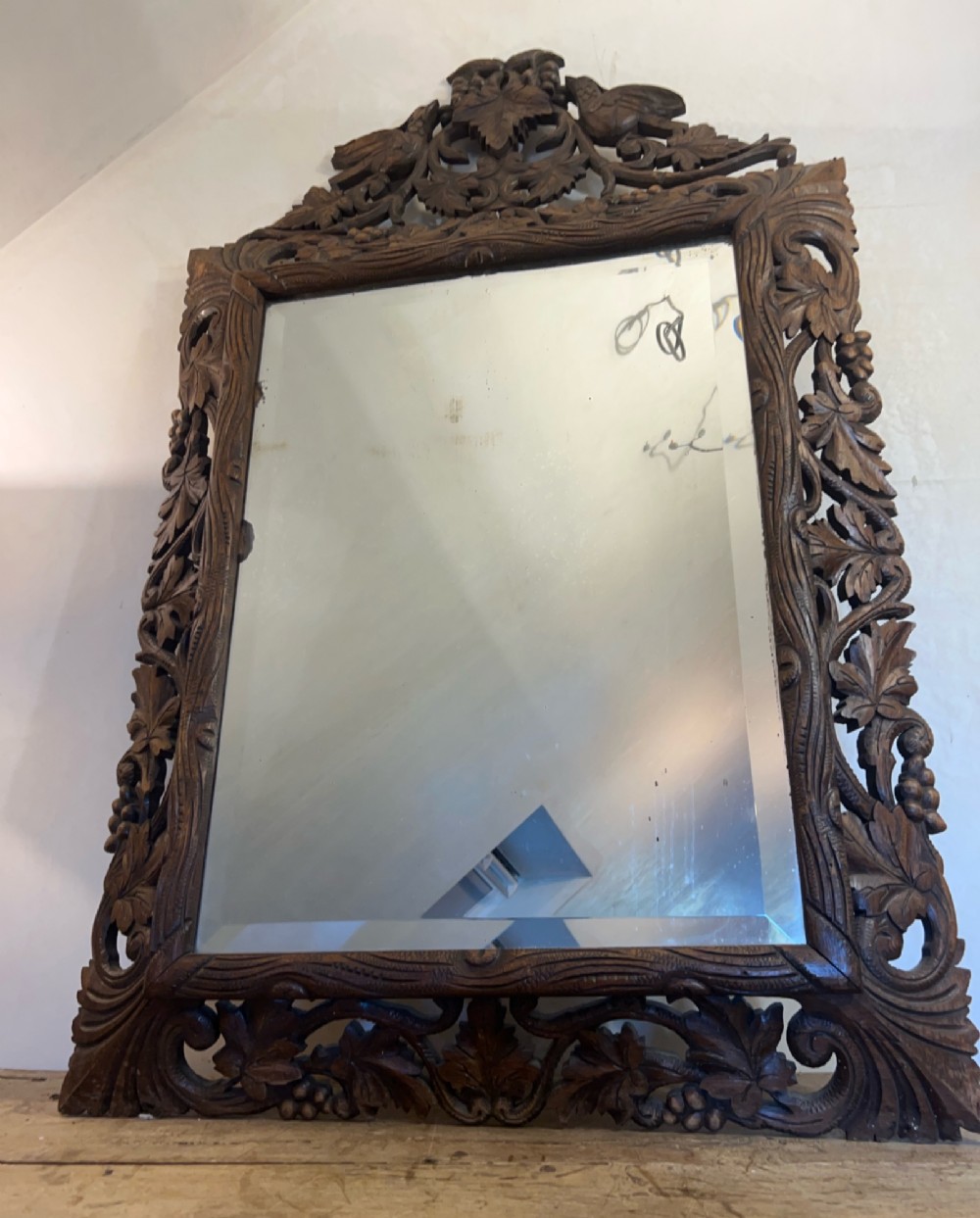 An ornate French oak wall mirror featuring intricate hand-carved leaf and grapevine motifs around a rectangular glass plate. View II