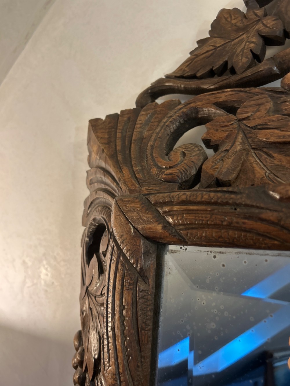 An ornate French oak wall mirror featuring intricate hand-carved leaf and grapevine motifs around a rectangular glass plate. View VI