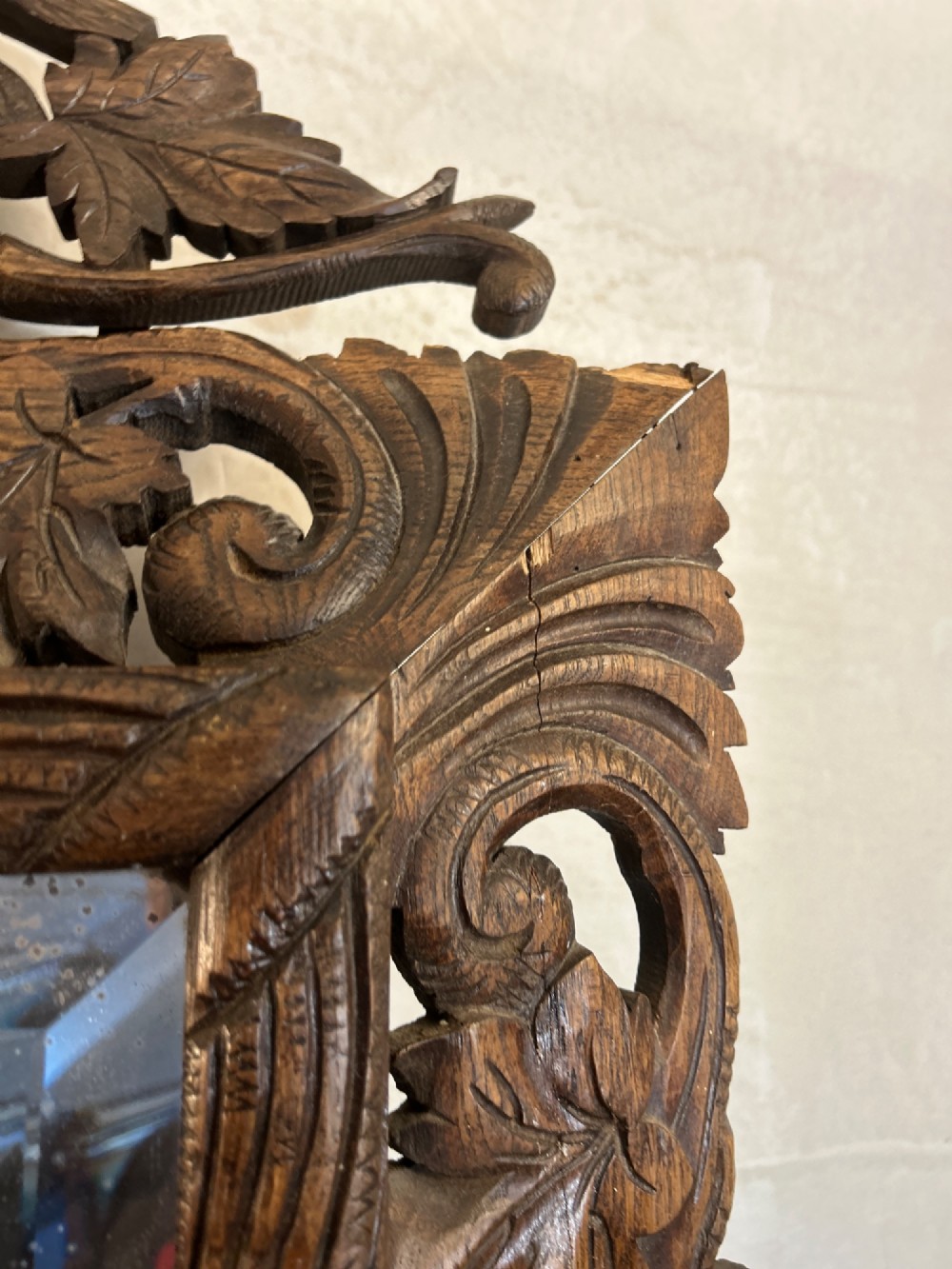 An ornate French oak wall mirror featuring intricate hand-carved leaf and grapevine motifs around a rectangular glass plate. View VII