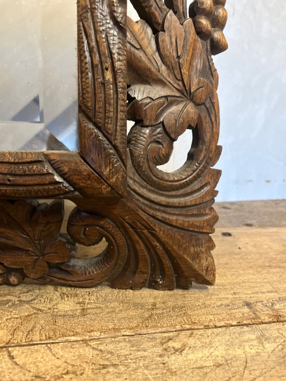 An ornate French oak wall mirror featuring intricate hand-carved leaf and grapevine motifs around a rectangular glass plate. View VIII